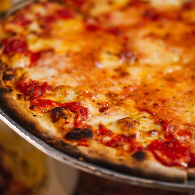 A close up of the edge of a pizza fromJohn’s of Bleecker Street – Most popular pizza places in Manhattan 2025